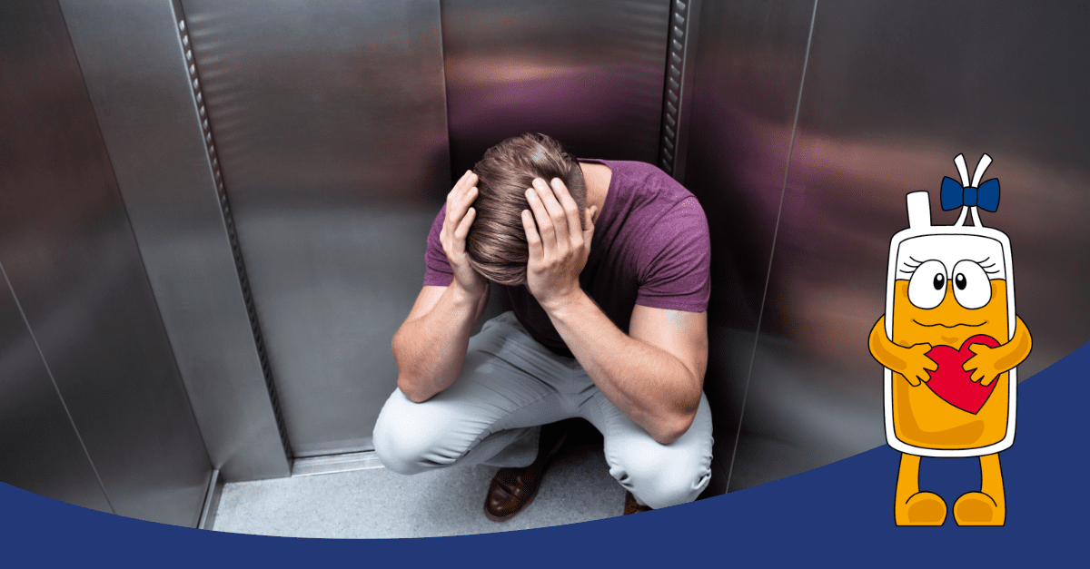 Egy férfi összegörnyedve ül egy liftben, kezét a fején tartva, szimbolizálva a klausztrofóbiával kapcsolatos szorongást. Az előtérben egy rajzolt vérplazma karakter szívet tart a kezében, bátorítva a vérplazma adásra. 