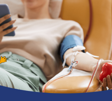 Egy nő kényelmesen ül egy székben, miközben vérplazmát ad és közben telefonját használja. A kezében egy piros stresszlabda van.