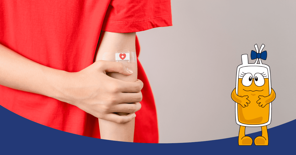 Egy személy piros pólóban fogja a karját, amelyen egy sebtapasz van szív szimbólummal, jelezve, hogy nemrég vérplazmát adott.